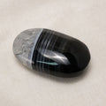 The Black Lace Agate Palm Stone is a powerful healing crystal known for its intricate patterns and grounding properties